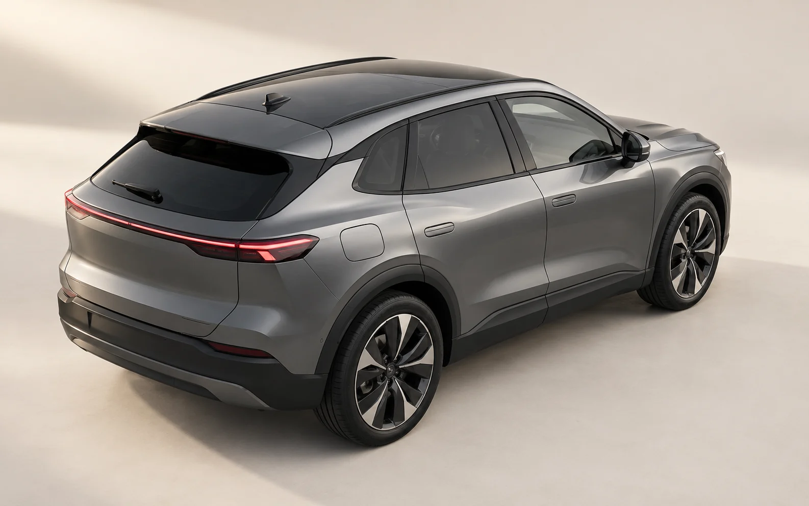 Conceptual graphite vehicle viewed from above its rear quarter, showing the closed charging flap and surrounding exterior.